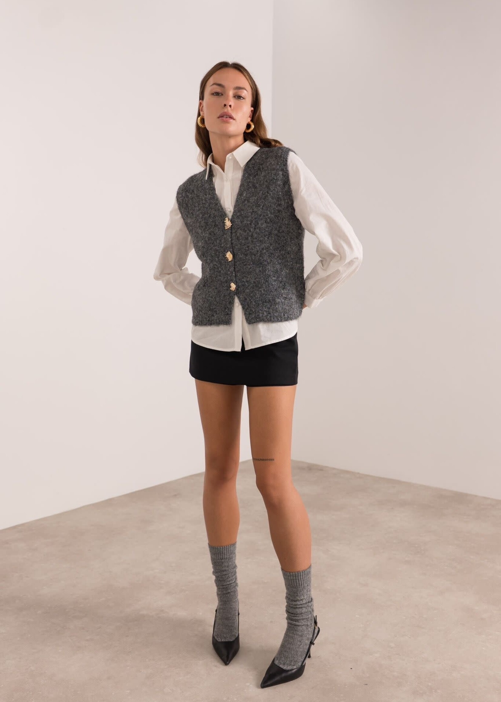 Gilet gris sans manches, orné de boutons dorés. Élégant et facile à associer, en taille unique.