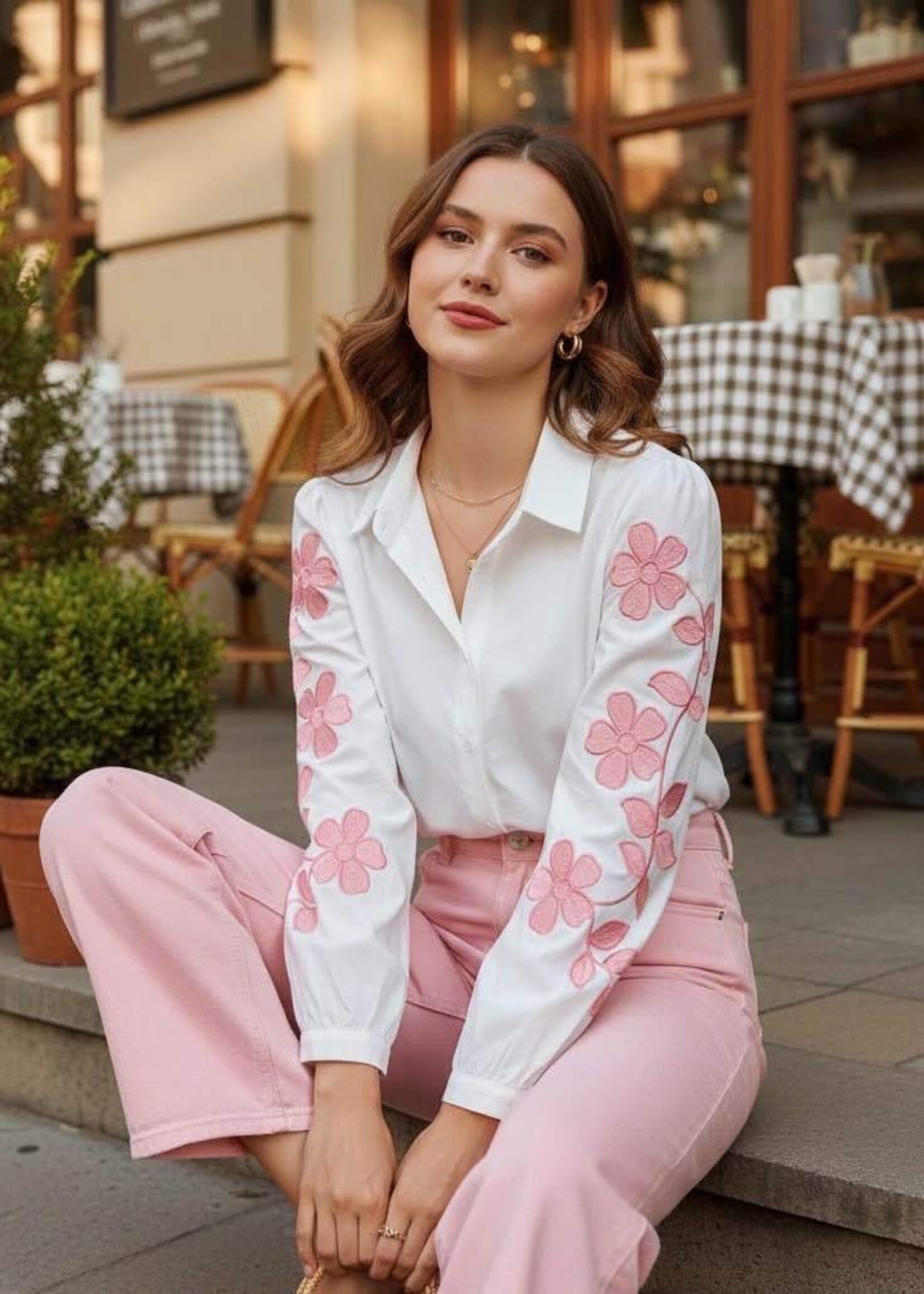 Wit hemd met roze bloemenborduursels op de mouwen