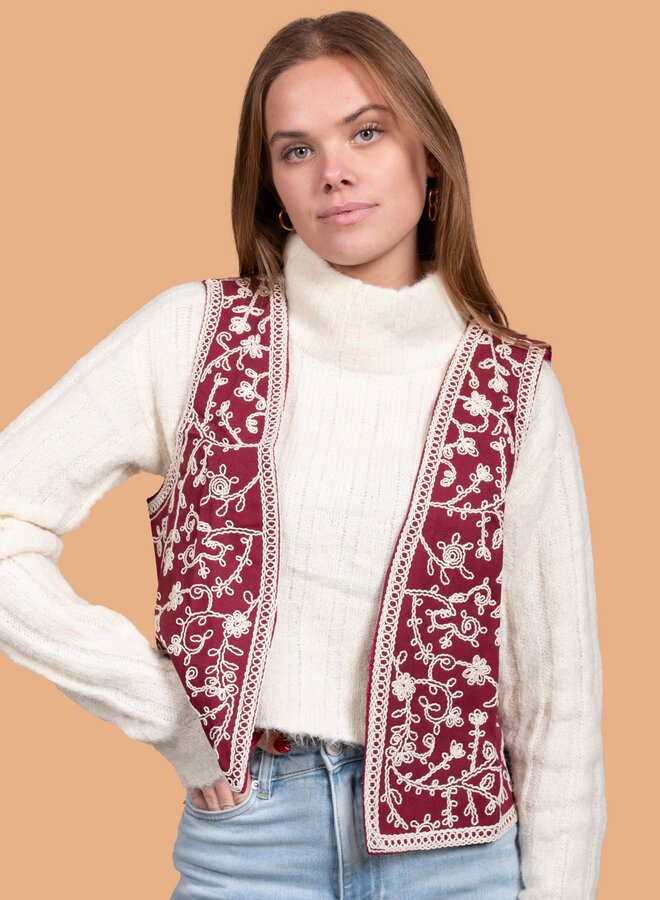 Rood gilet met witte borduursels