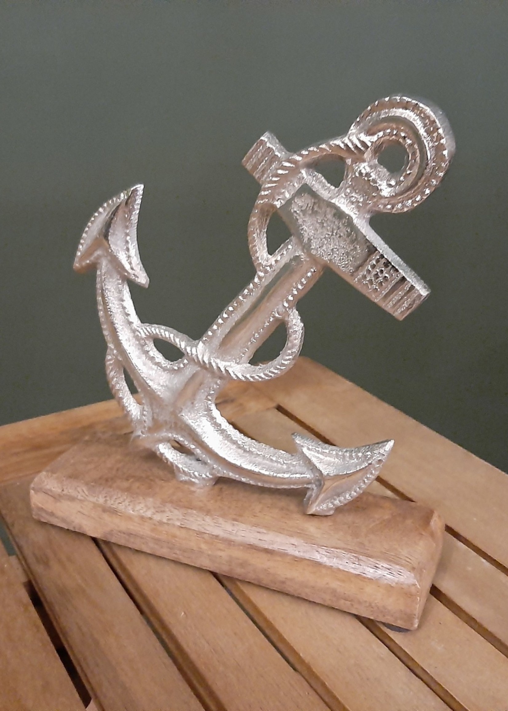 Silver colored nostalgic metal anchor with wooden base