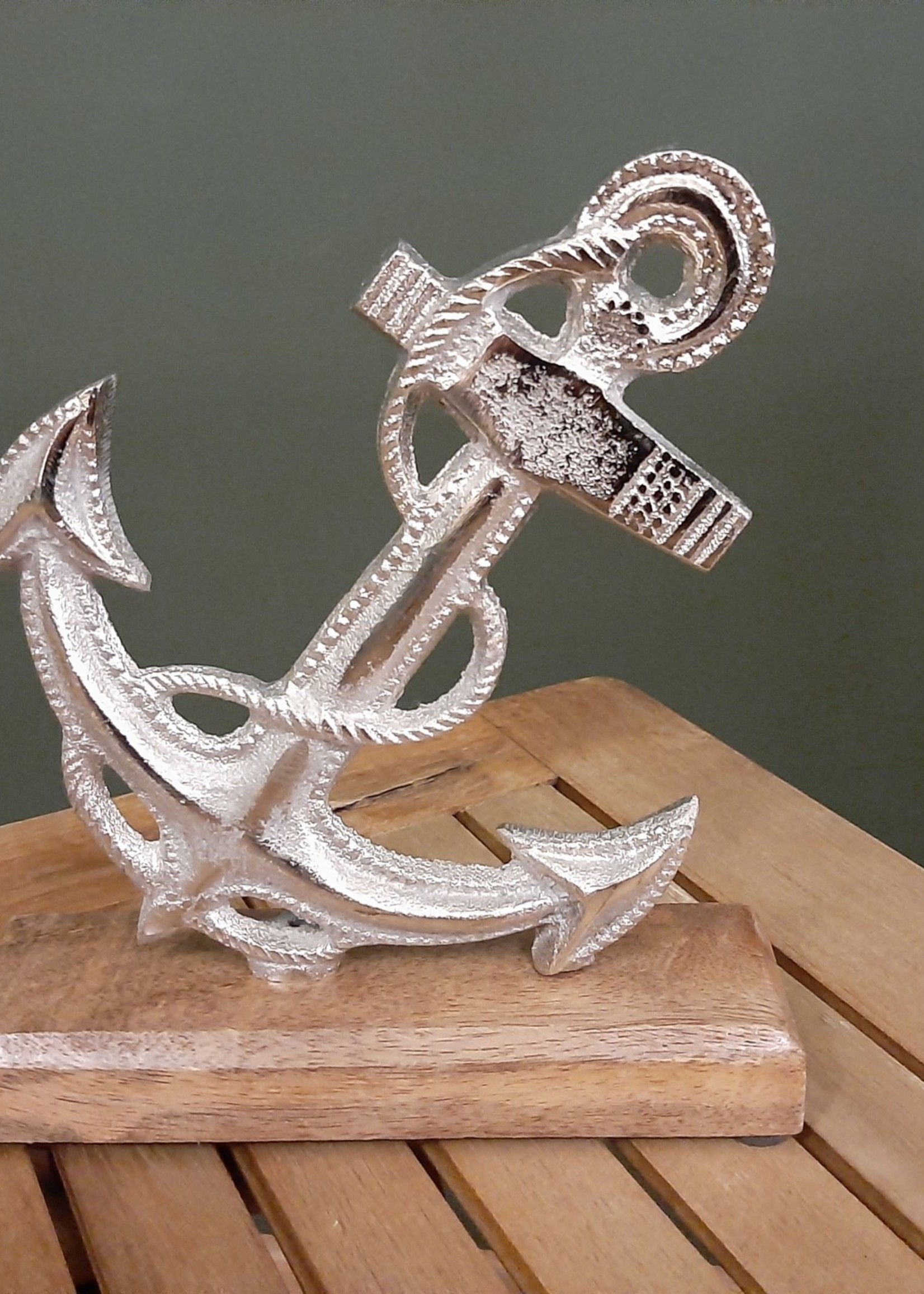 Silver colored nostalgic metal anchor with wooden base