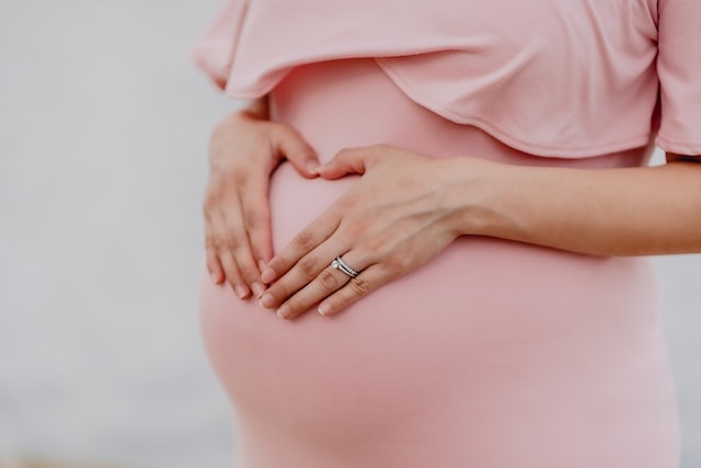 zwangere vrouw met handen op buik tijdens babyshower