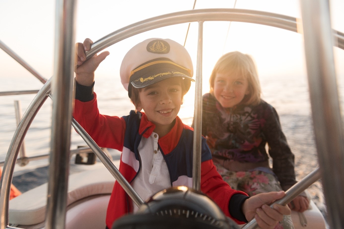 Moeder betrekt zoon bij het varen door hem de boot te laten besturen terwijl ze toekijkt