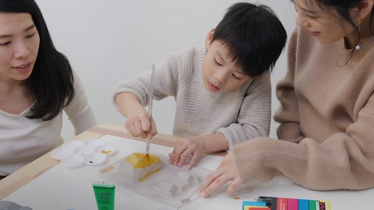 A child painting a model car that was moulded with a vacuum former