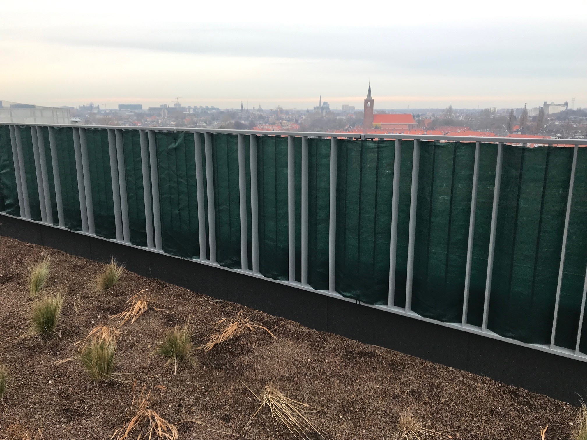 Winddoek tegen hekwerk op balkon