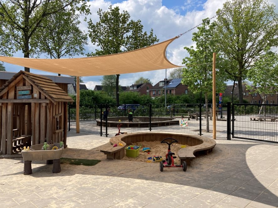 Met een schaduwdoek van ZONZ boven de zandbak spelen de kinderen veilig in de schaduw