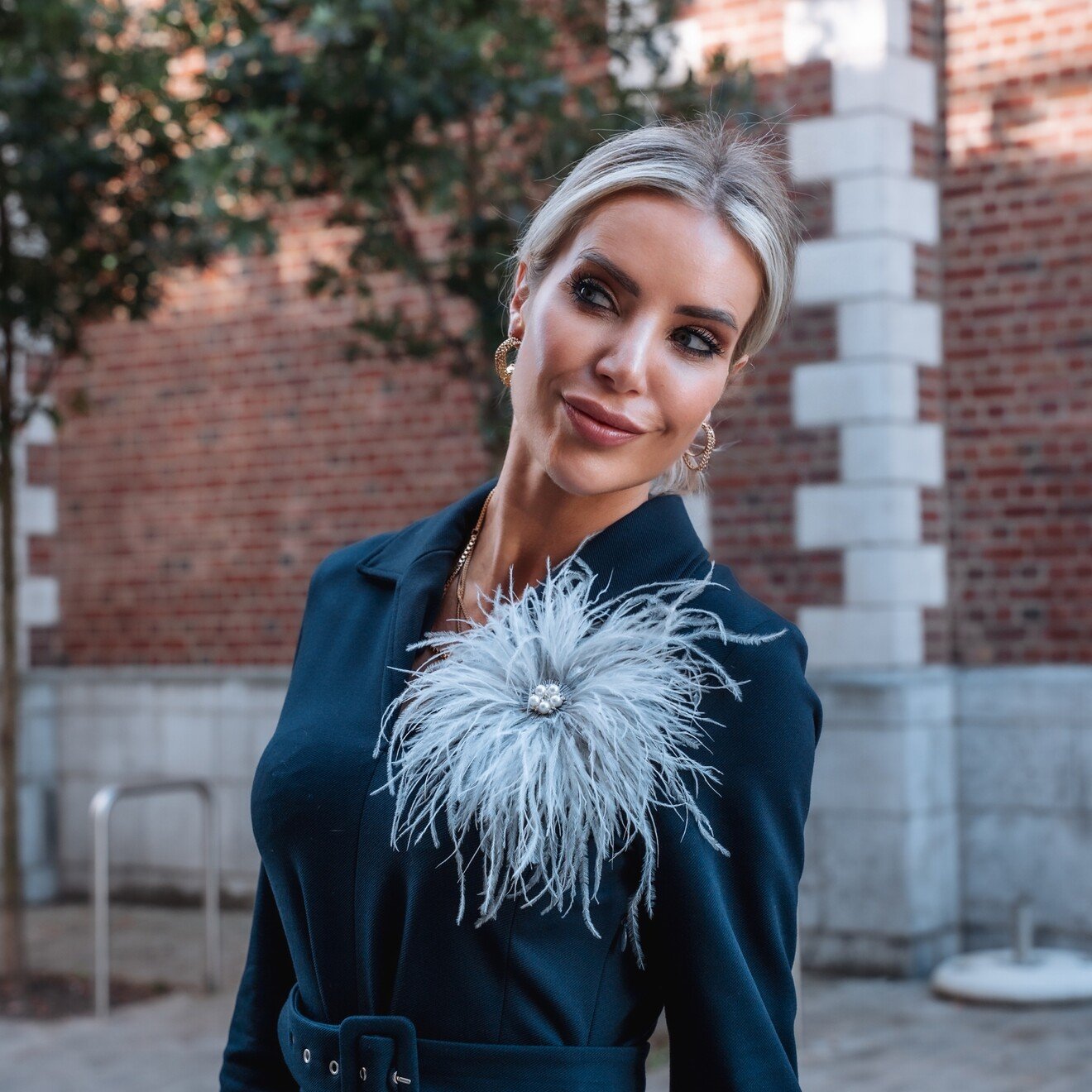 Broche struisvogelveren lichtgrijs met pareltjes