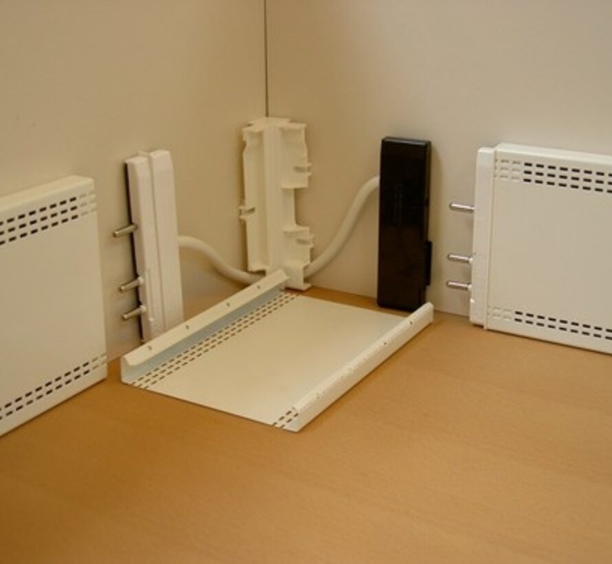 Un connecteur d'angle Elpan   (M) pour chauffage en plinthe est utilisé dans les coins pour pincer deux panneaux solidement contre le mur.