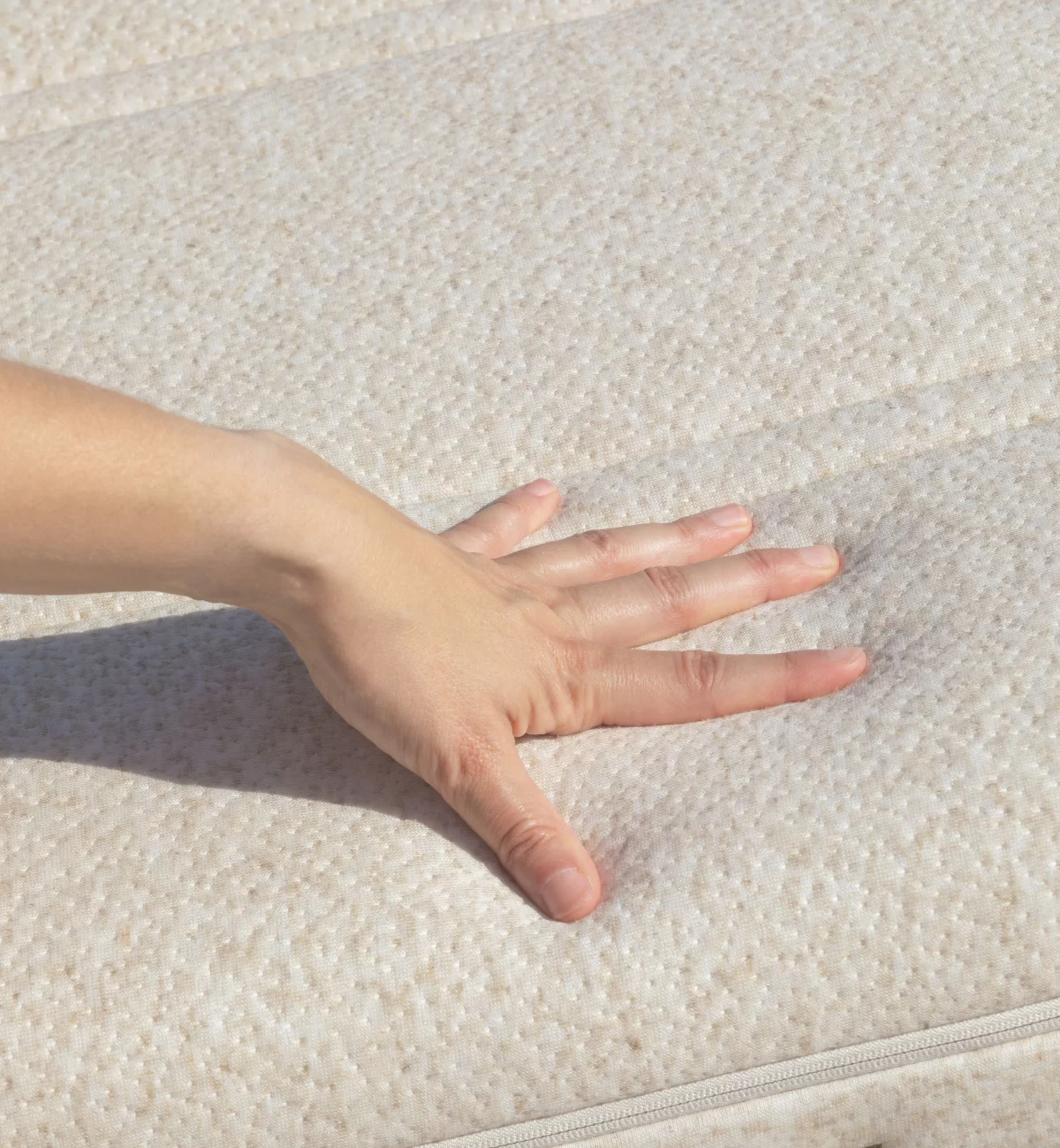 Matelas chanvrenatura de kadolis avec main qui montre le coté moelleux et confortable