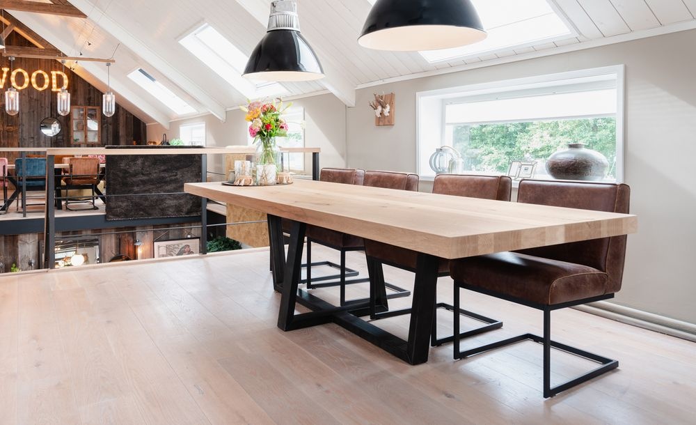 Lichte eiken eettafel met zwart onderstel en leren eetkamerstoelen