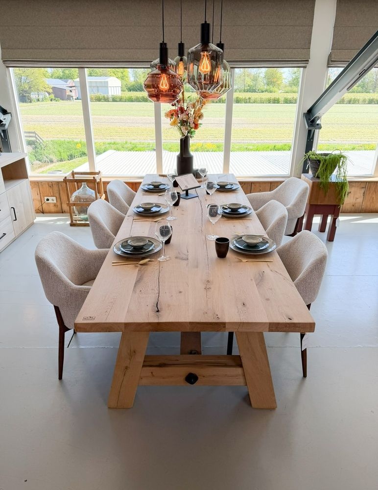 Robuuste eiken eettafel met schragenpoot en gestoffeerde stoelen