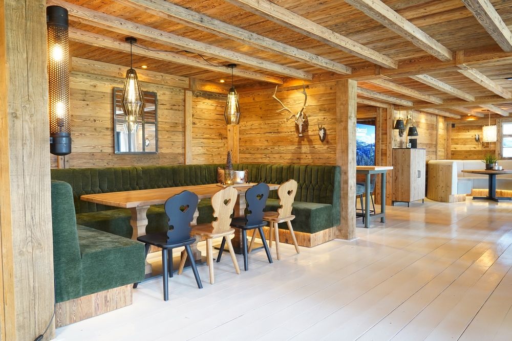 Alpenhoek met groene hoekbank, houten tafel en Stube stoelen