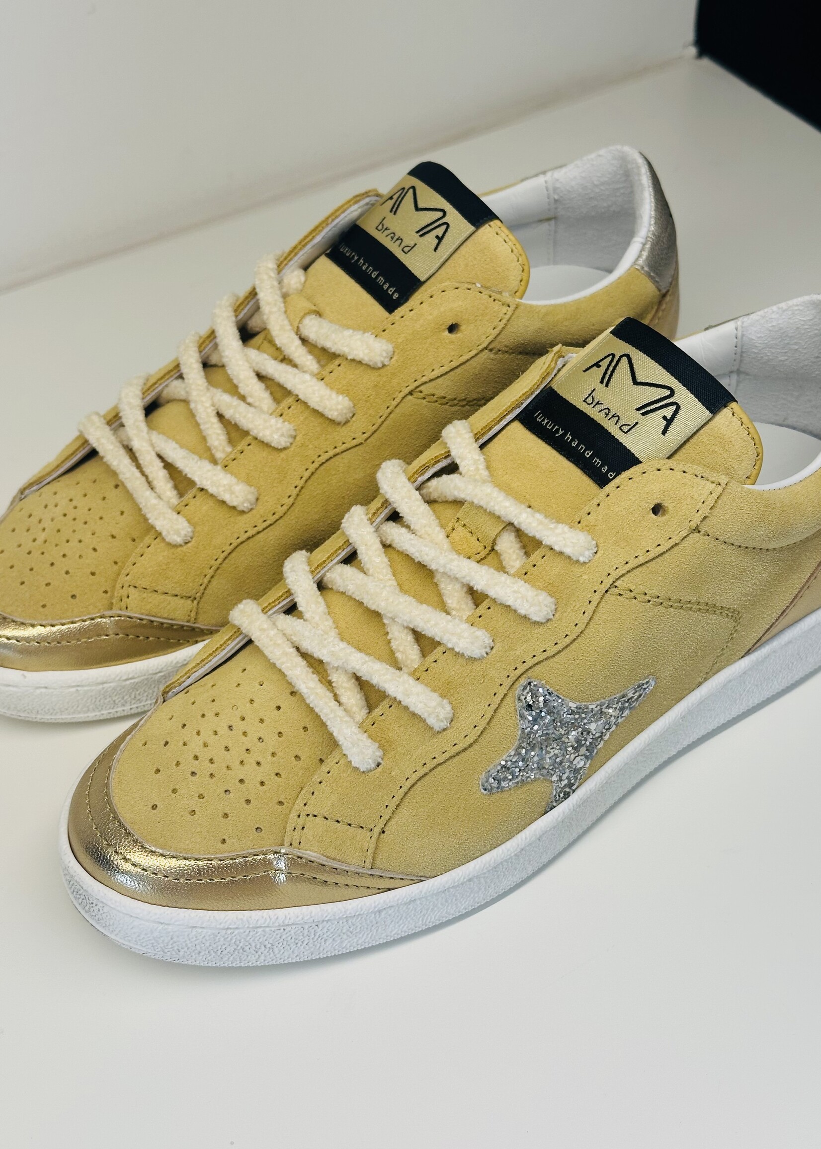 Lichtgele sneaker met gouden accenten