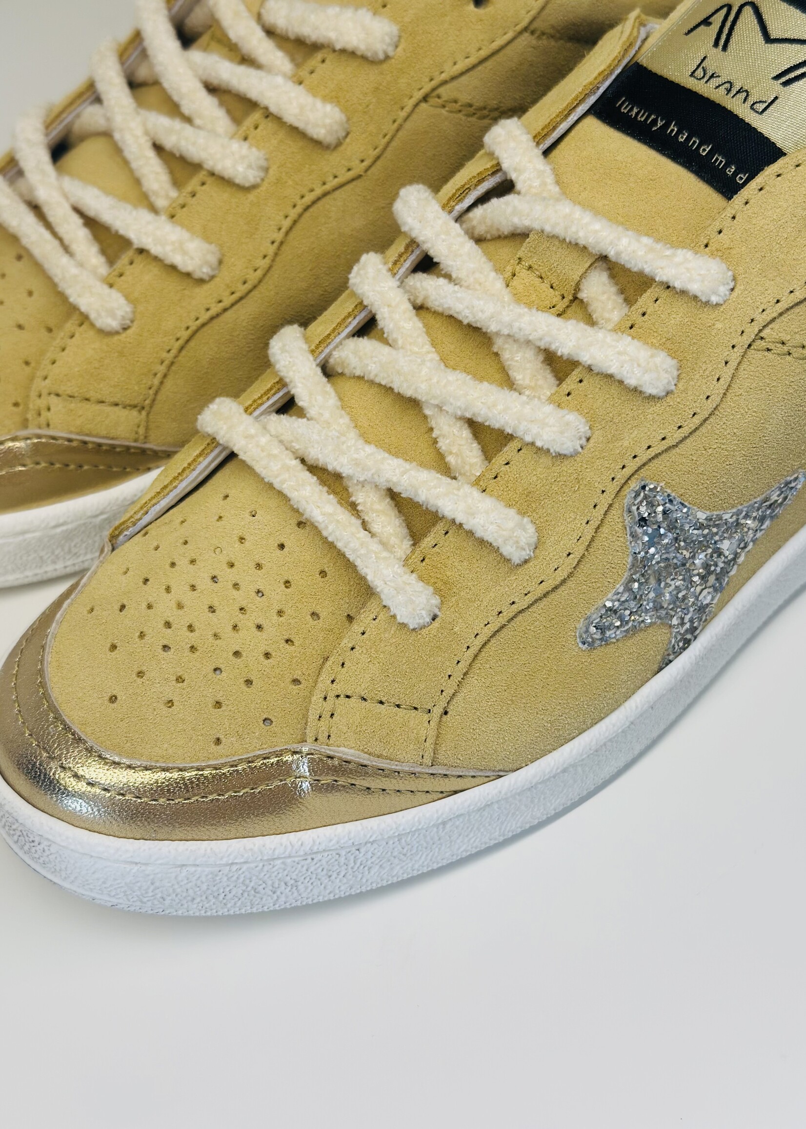 Lichtgele sneaker met gouden accenten