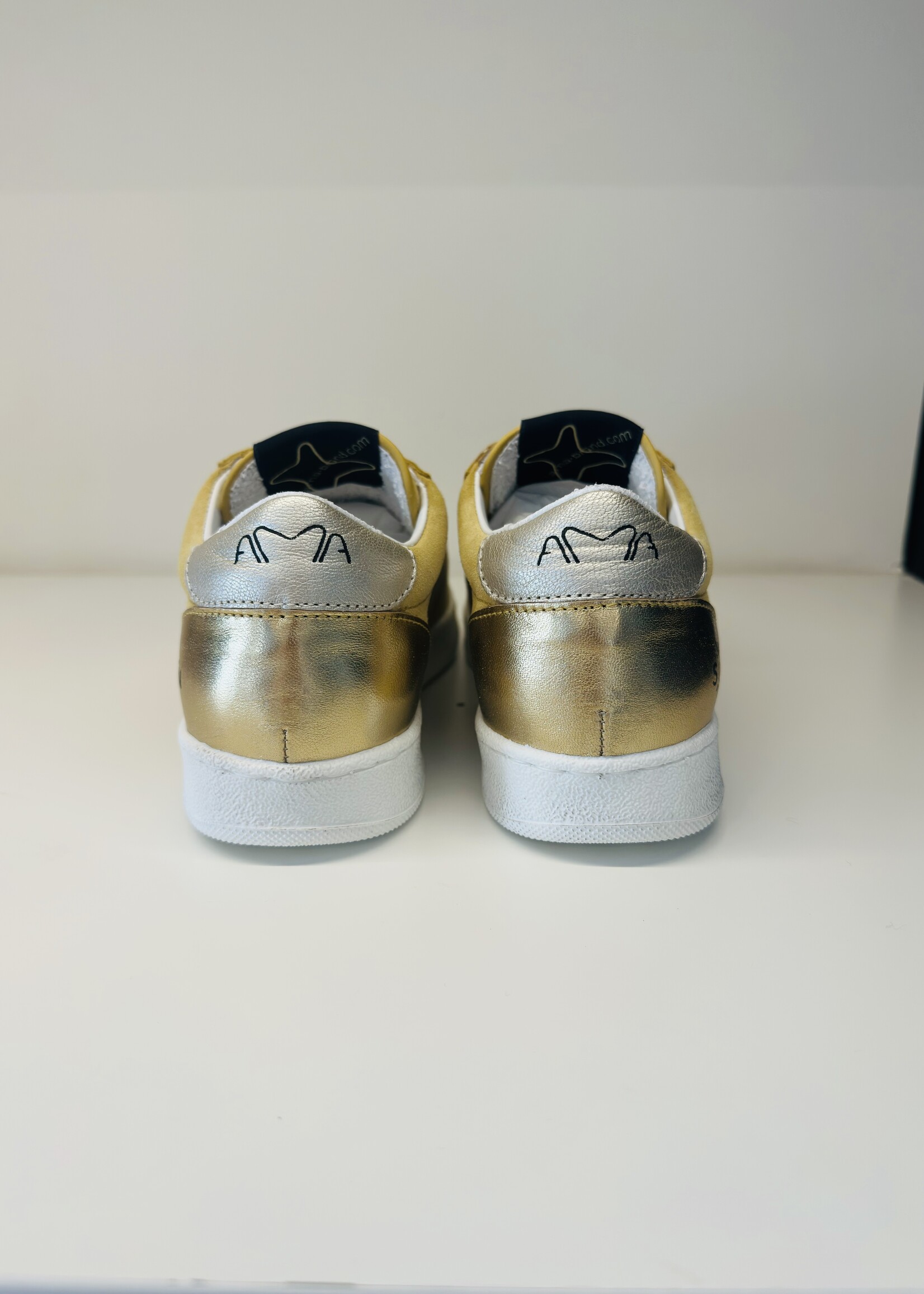 Lichtgele sneaker met gouden accenten