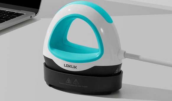 Side view of the LOKLIK Mini Heat Press LOKLIK Blue on a white table with on the left th e side of a laptop.