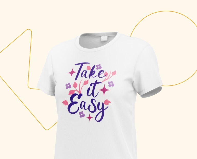 A white T-shirt with an iron-on print of a design with the text 'Take it Easy' in dark purple with lilac flowers and pink stars scattered around it.