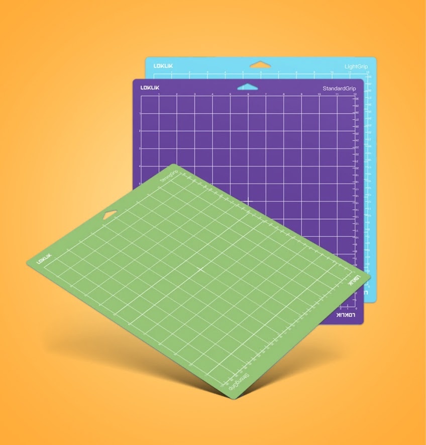 Three LOKLiK cutting mats in green, purple and blue on a light orange background.