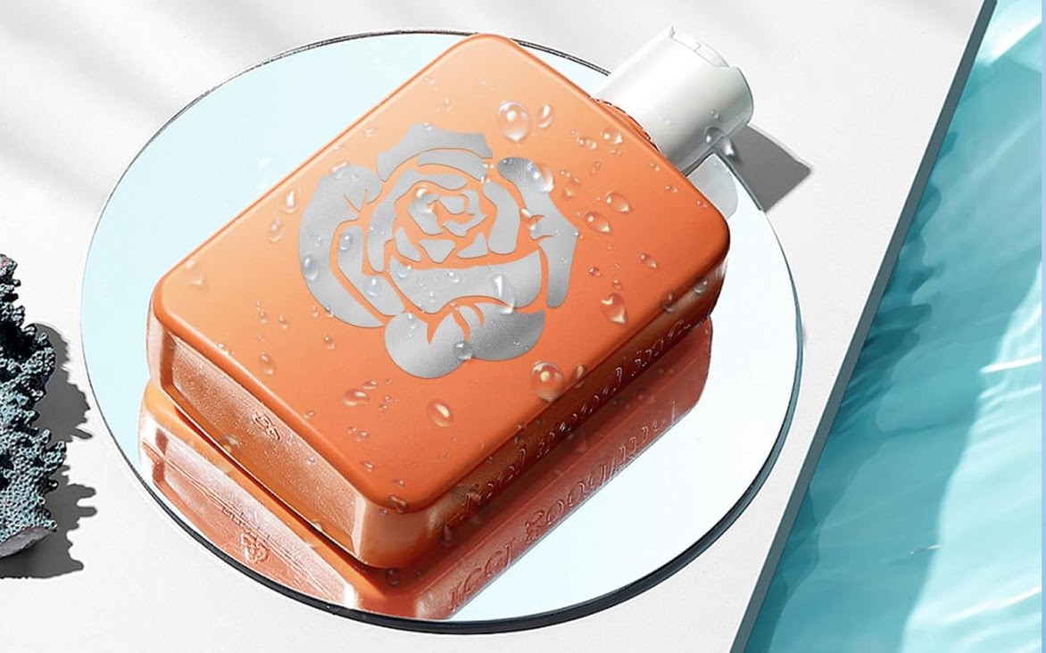 Flacone di sapone in plastica arancione appoggiato su uno specchio. Ha una decalcomania di una rosa in vinile adesivo permanente metallizzato a specchio.