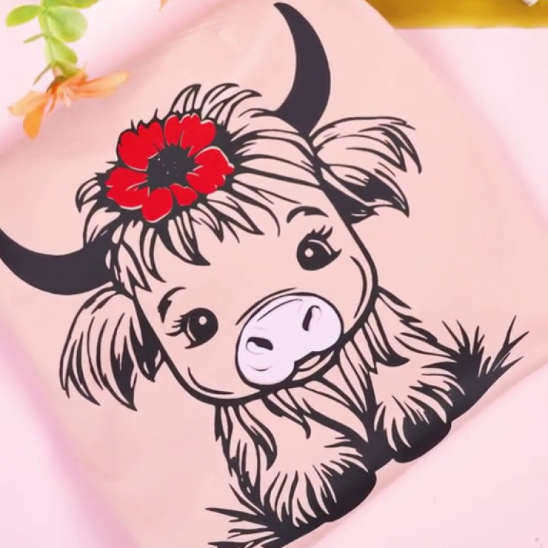 Light pink shirt with a heat transfer design of a cute cow in black vinyl.
