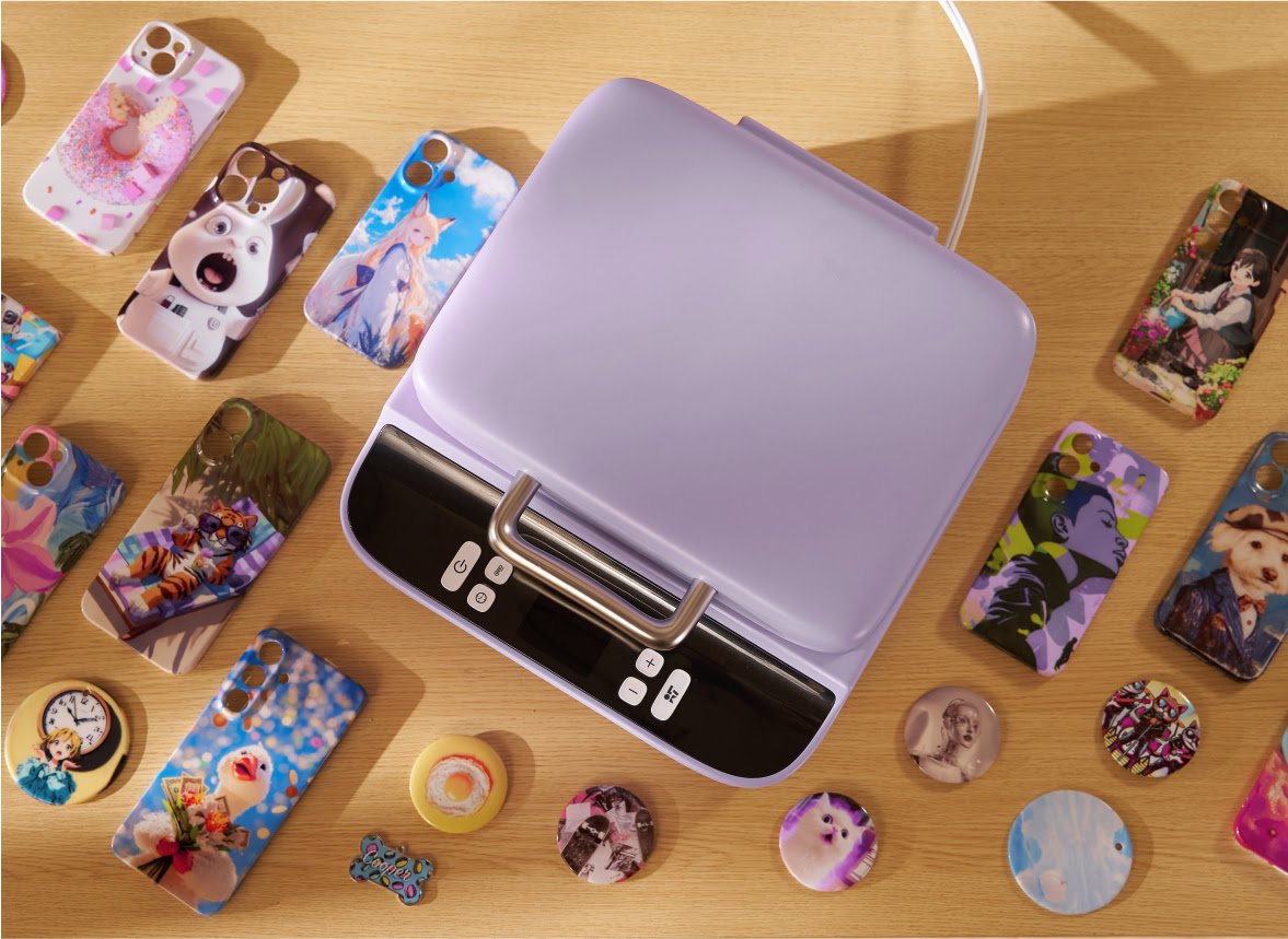 Een LOKLiK Phone Case Heat Press in lavendel paars van bovenaf gezien. Het is omringd met voorbeelden van gepersonaliseerde telefoonhoesjes, button pins, onderzetters en dog tags.
