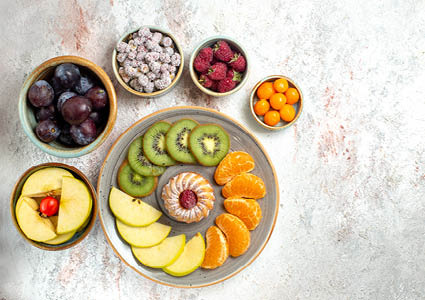 Een bovenaanzicht van kommen en borden gevuld met fruit en vitamines