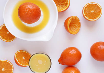 Een bovenaanzicht van sinaasappels die geperst worden voor sinaasappelsap