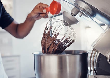 Een keukenmixer die beslag aan het mixen is voor een cake