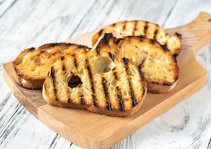 Een houten snijplank met geroosterd brood