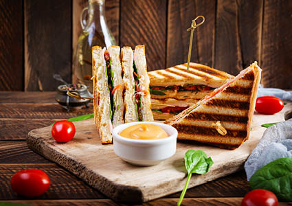 Gegrilde tosti geserveerd op een houten snijplank