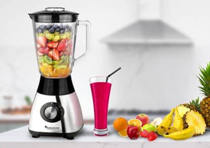 Een zilveren blender met een glazen kan en een roze smoothie