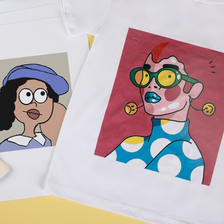Two white T-shirts with a heat transfer print of a cartoon face.