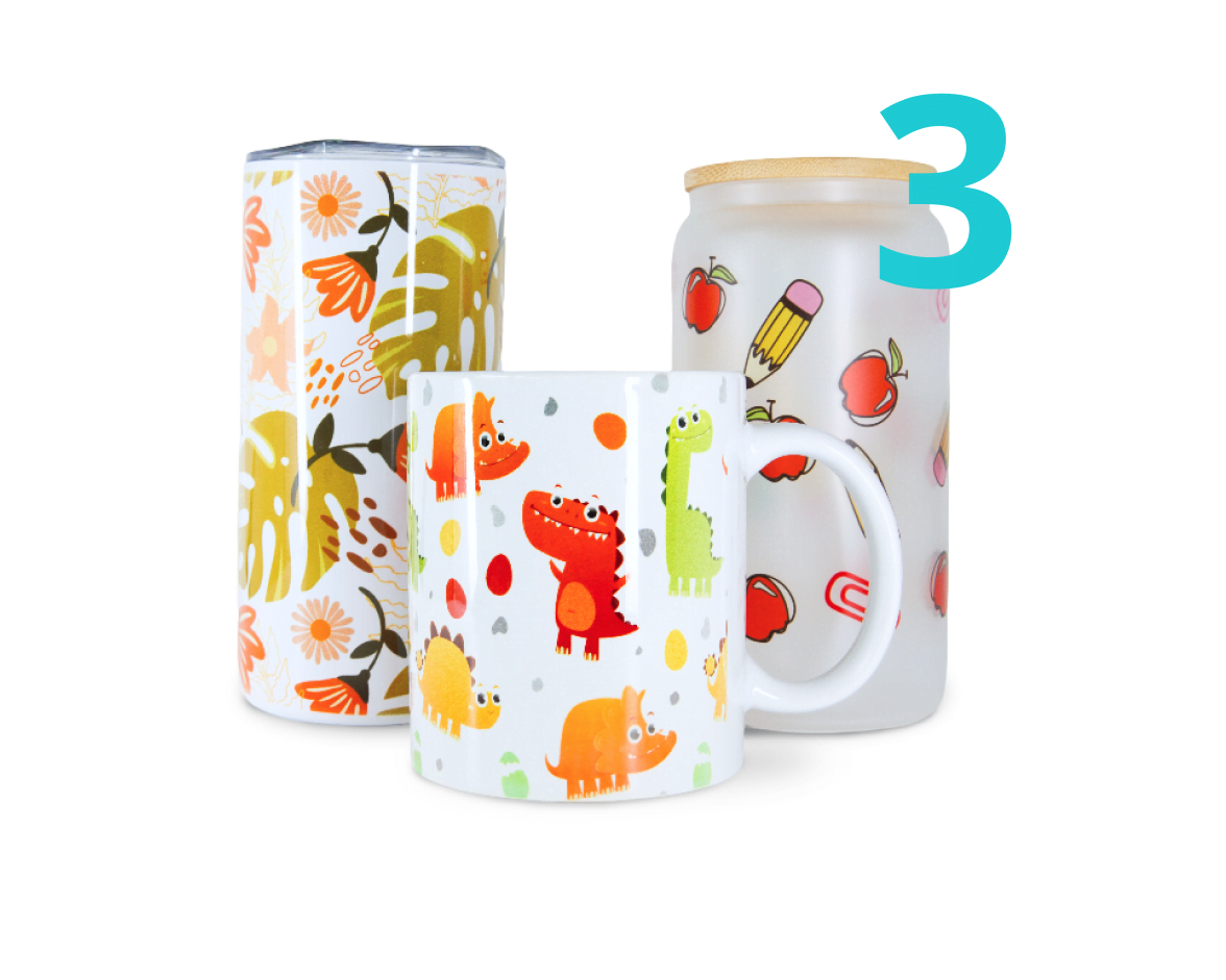 A mug with dinosaur sublimation print, tumbler with leaves and flowers and glass yars with apples and pencils.