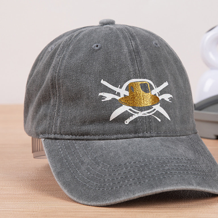 Grey cap with a design of a hat in front of snakes and knives in white and gold vinyl.