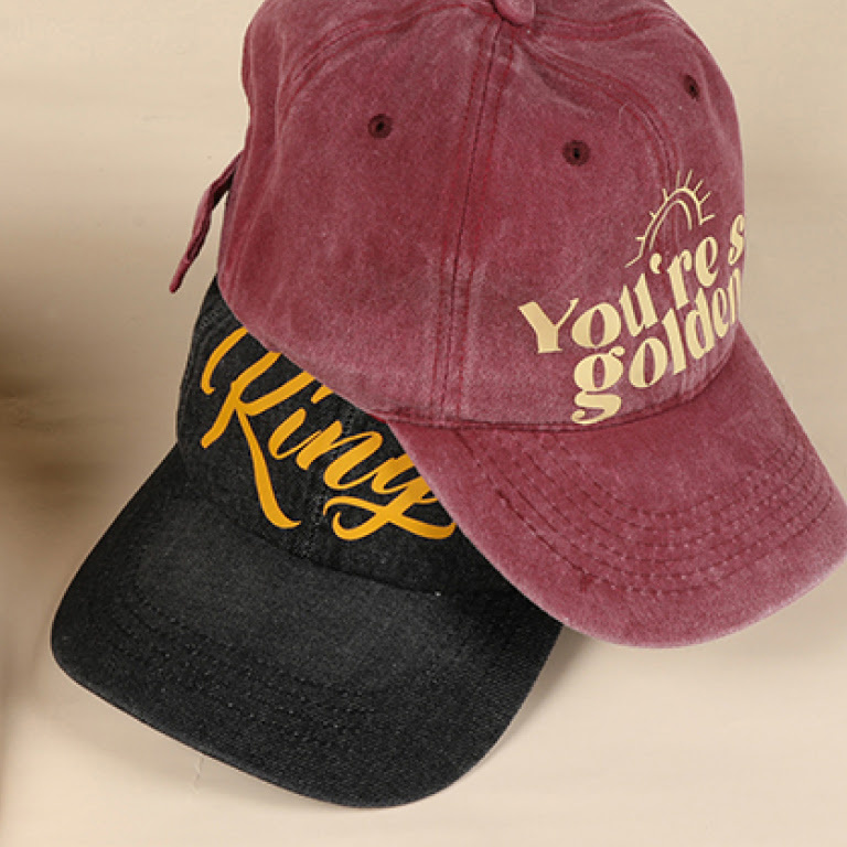 Burgundy hat with the words 'You're so golden' ironed on and a black capp with 'King'.