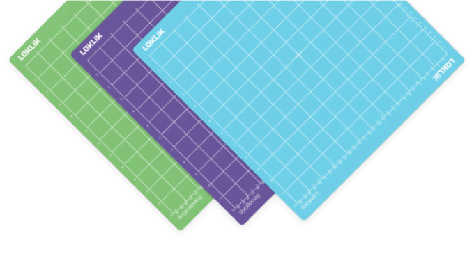 Three cutting mats in green, purple and blue at a 45 degree angle .