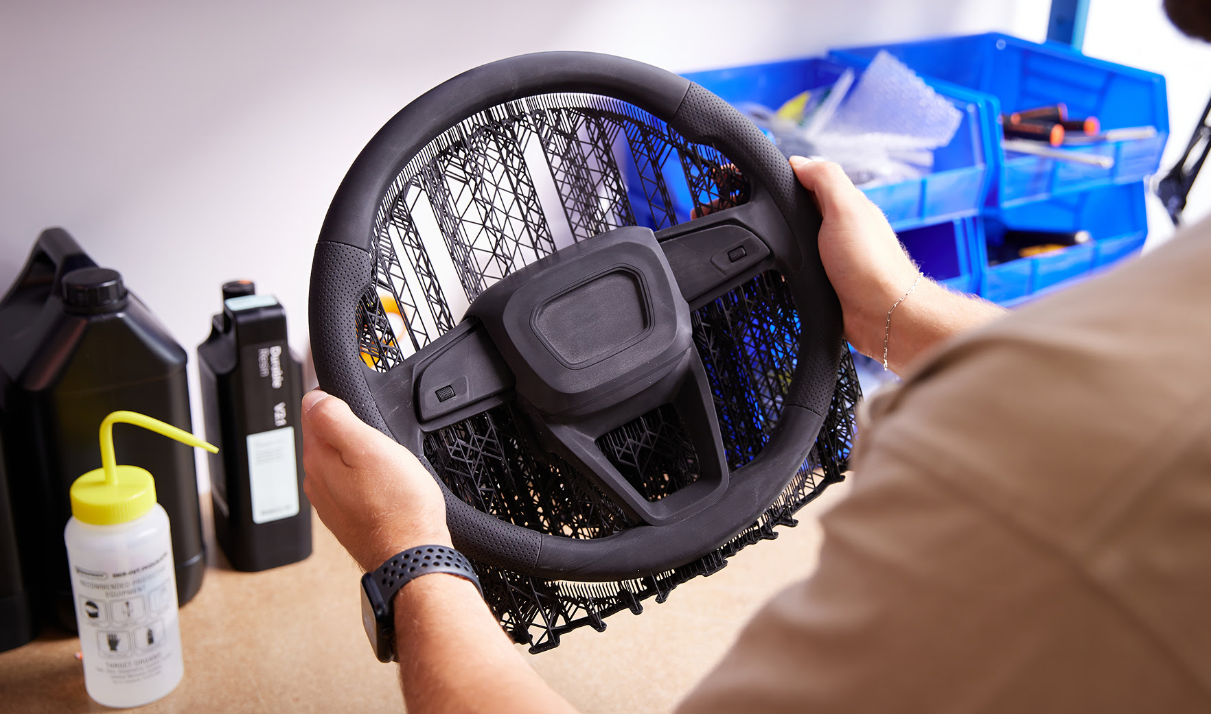 Two hands holding a 3D printed steering wheel.