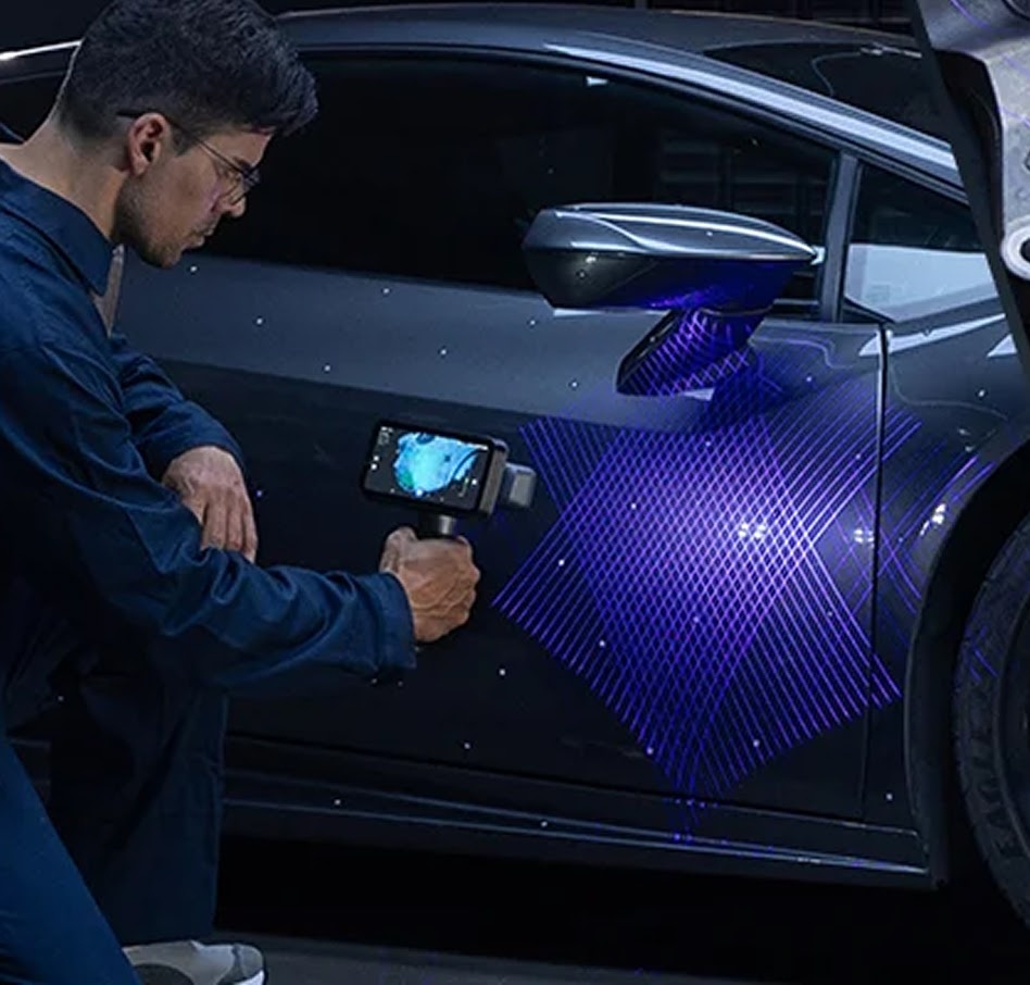 Man 3D scanning the door of a car.