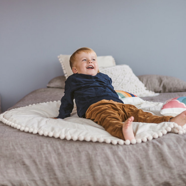 Tapis de jeu rond avec pompons décoratifs – Écru | Doux et confortable