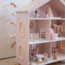 Pink wooden dollhouse with playful details