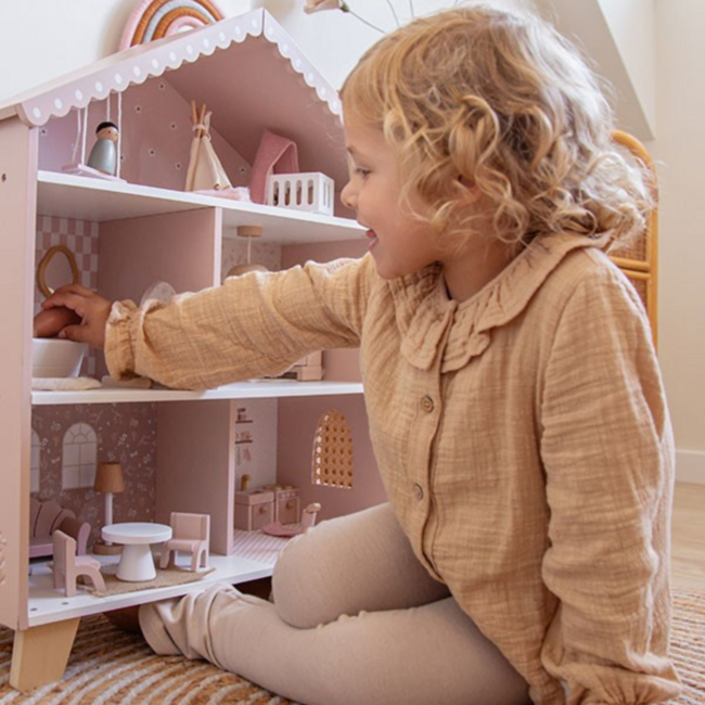 Pink wooden dollhouse with playful details