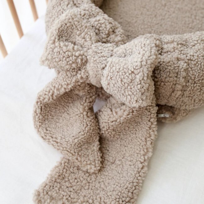 Nid d’enfant avec nœud en tissu teddy taupé – doux, sûr et confortable pour bébé