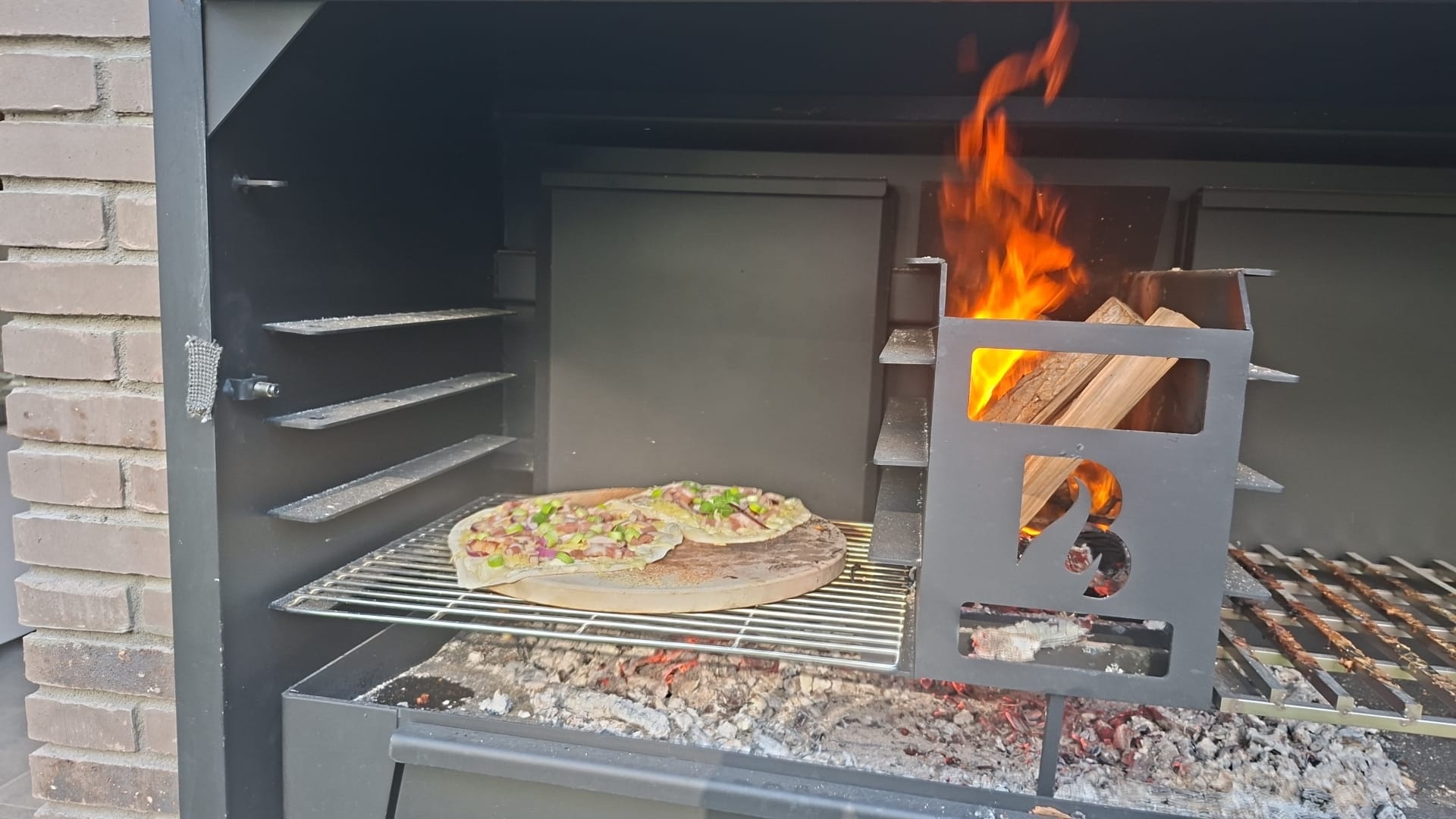 Brandend hout in de ember maker van een BRANT Inbouw Braai 120 cm