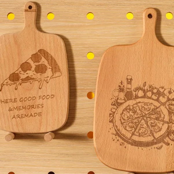 Two cutting boards with laser engraved designs of a slice of pizza and a whole pizza.