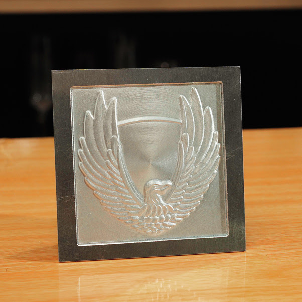 Square picture frame with a piece of aluminiums with a milled eagled spreading its wings.
