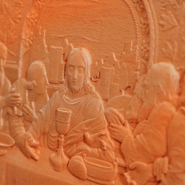 Close-up of a piece of beech wood and a routed scene from the last supper.