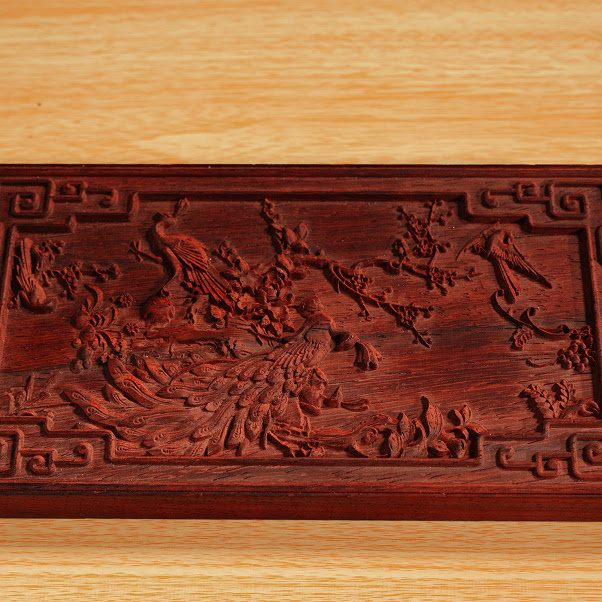 Piece of redwood with an intricate milled design of two peacocks on a branch