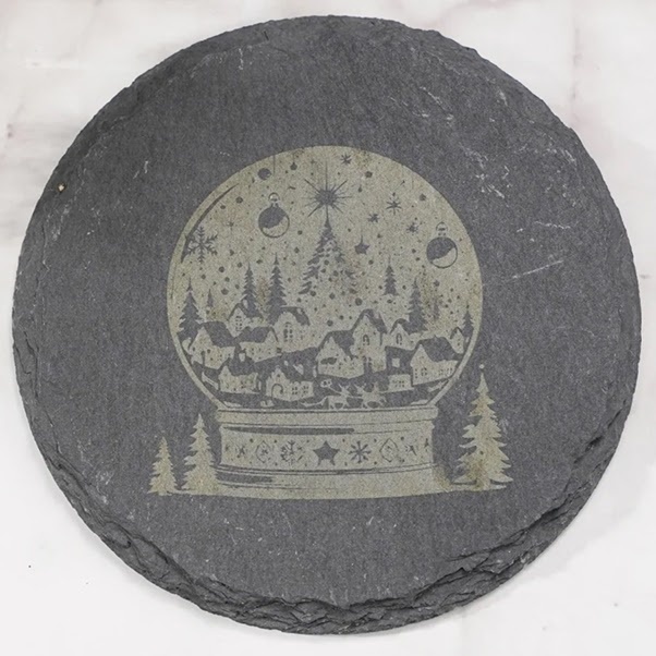 Round piece of slate with an engraved snowglobe.