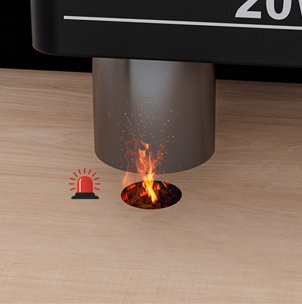 A close-up view of the AtomStack Fusion laser module engraving wood, featuring a small flare-up with flames and a red siren alarm icon indicating the activation of its flame detection safety feature.