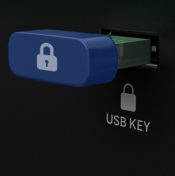 A close-up view of a blue security dongle inserted into a slot labeled 'USB KEY' with a padlock icon on the black chassis of an AtomStack machine, representing a hardware lock safety feature.